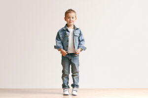 portrait-cute-little-kid-boy-stylish-jeans-clothes-looking-camera-against-white-studio-wall