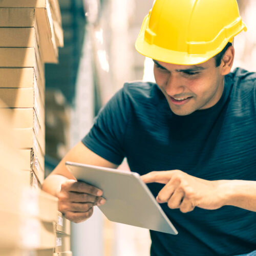 smart-indian-engineer-man-wearing-safety-helmet-doing-stock-tick-check-cardboard-stock-product-management-factory-warehouse-background